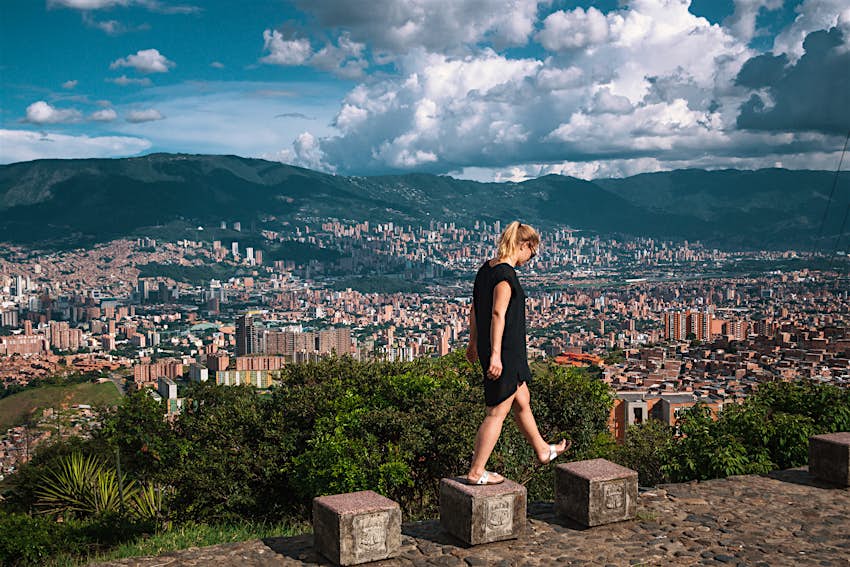 Mujer caminando sobre el paisaje urbano de Medellín 