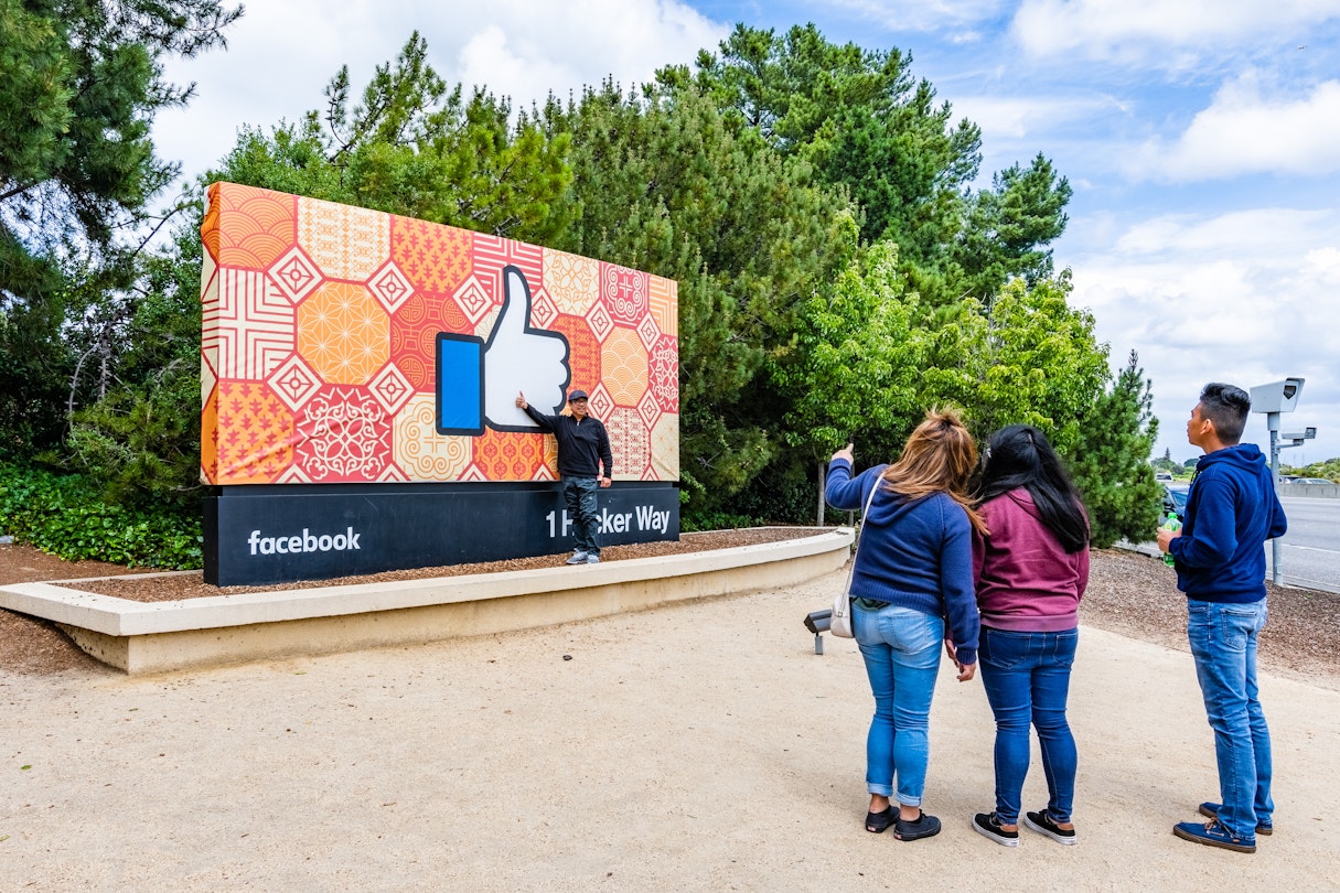 Tourists posing in front of the Facebook sign in Silicon Valley