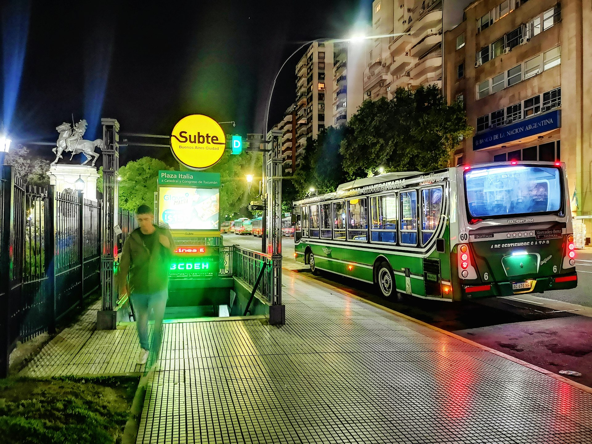 A man exits a subway station onto the Buenos Aires streets at night