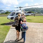 Castries, Saint Lucia - December 22, 2015: A woman and child walking towards a helicopter prior to boarding