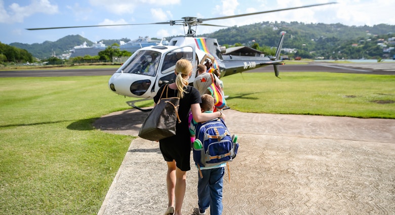 Castries, Saint Lucia - December 22, 2015: A woman and child walking towards a helicopter prior to boarding