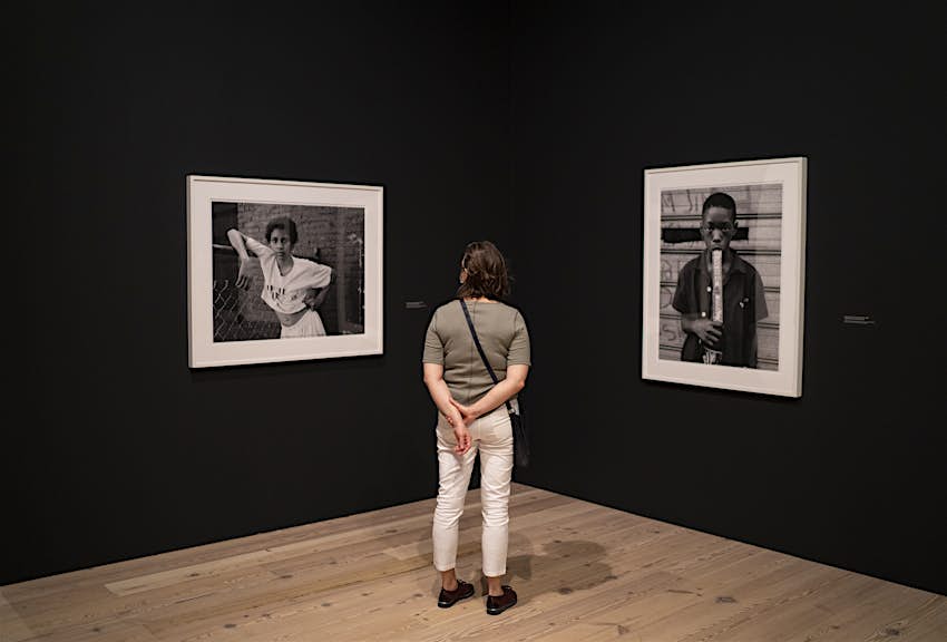 Museum enthusiast observes black-and-white photographs at the Whitney Museum of American Art