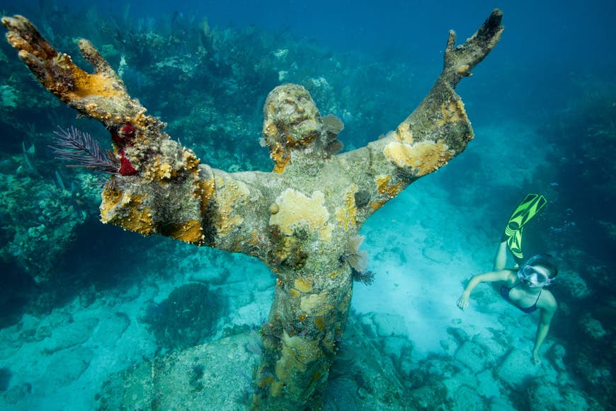 A snorkeler swims past the Statue of Christ of the Deep in the Florida Keys