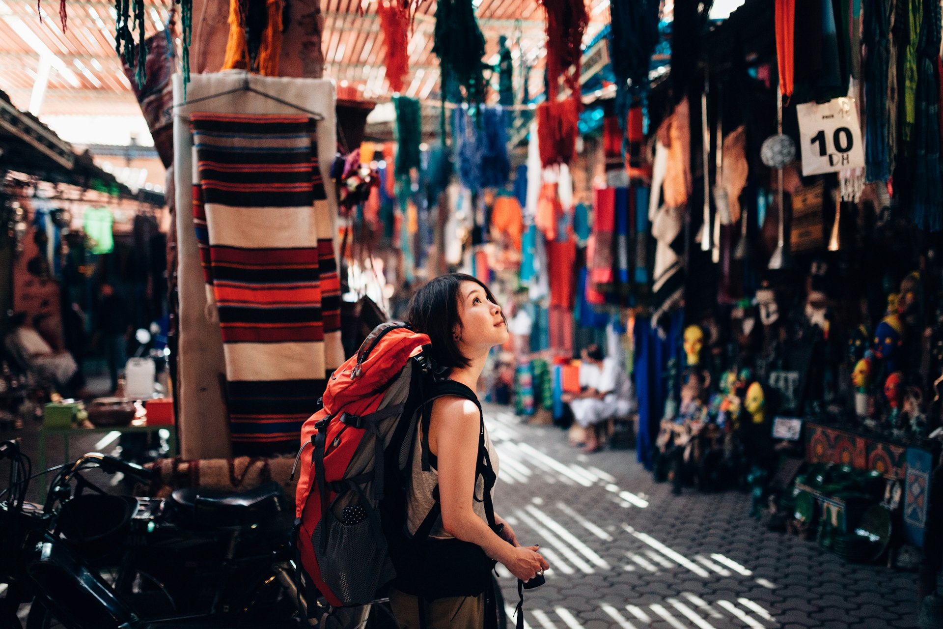 A female backpacker is walking around a local old market in Fez