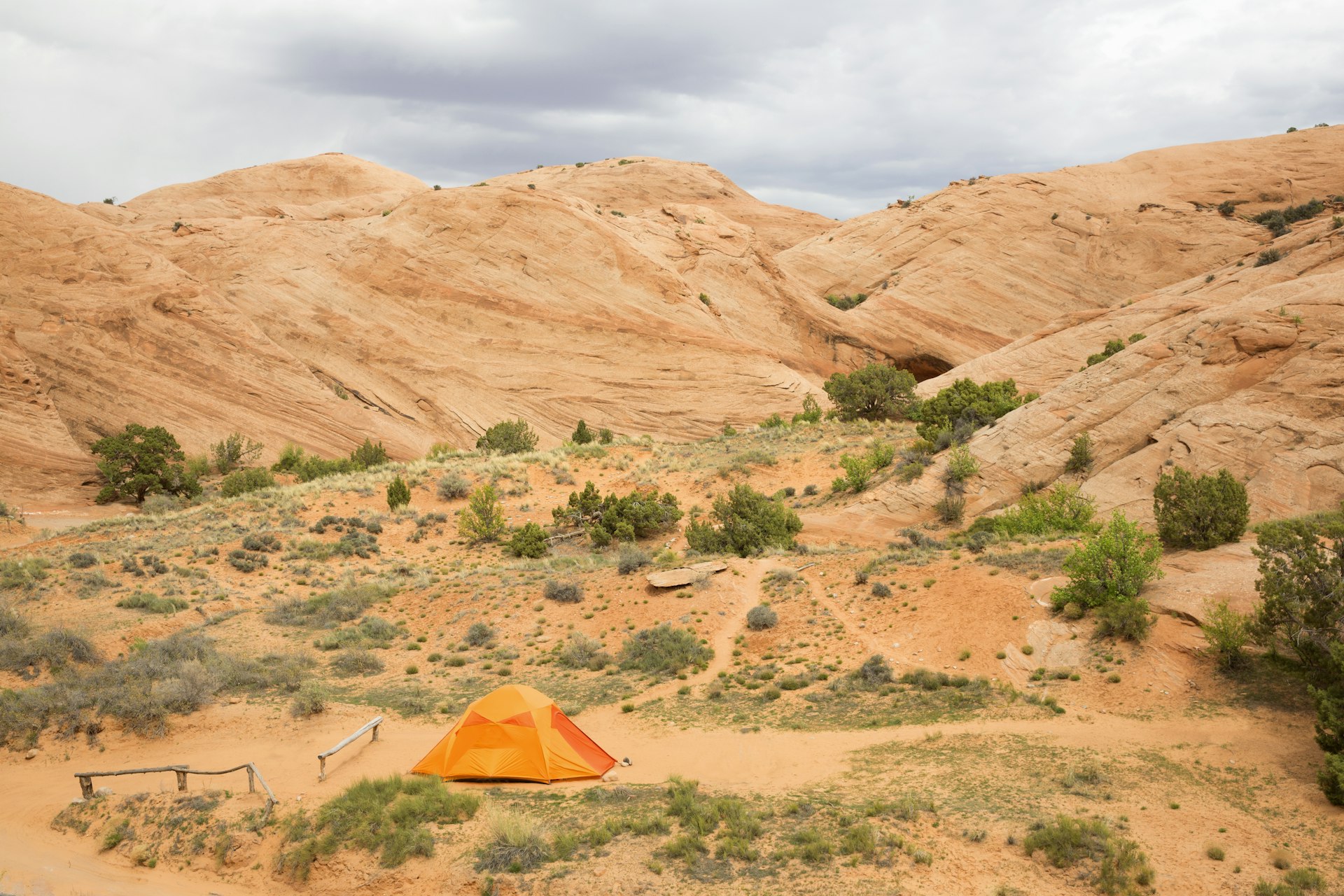 An orange tent sits among red rocks near Moab, Utah.