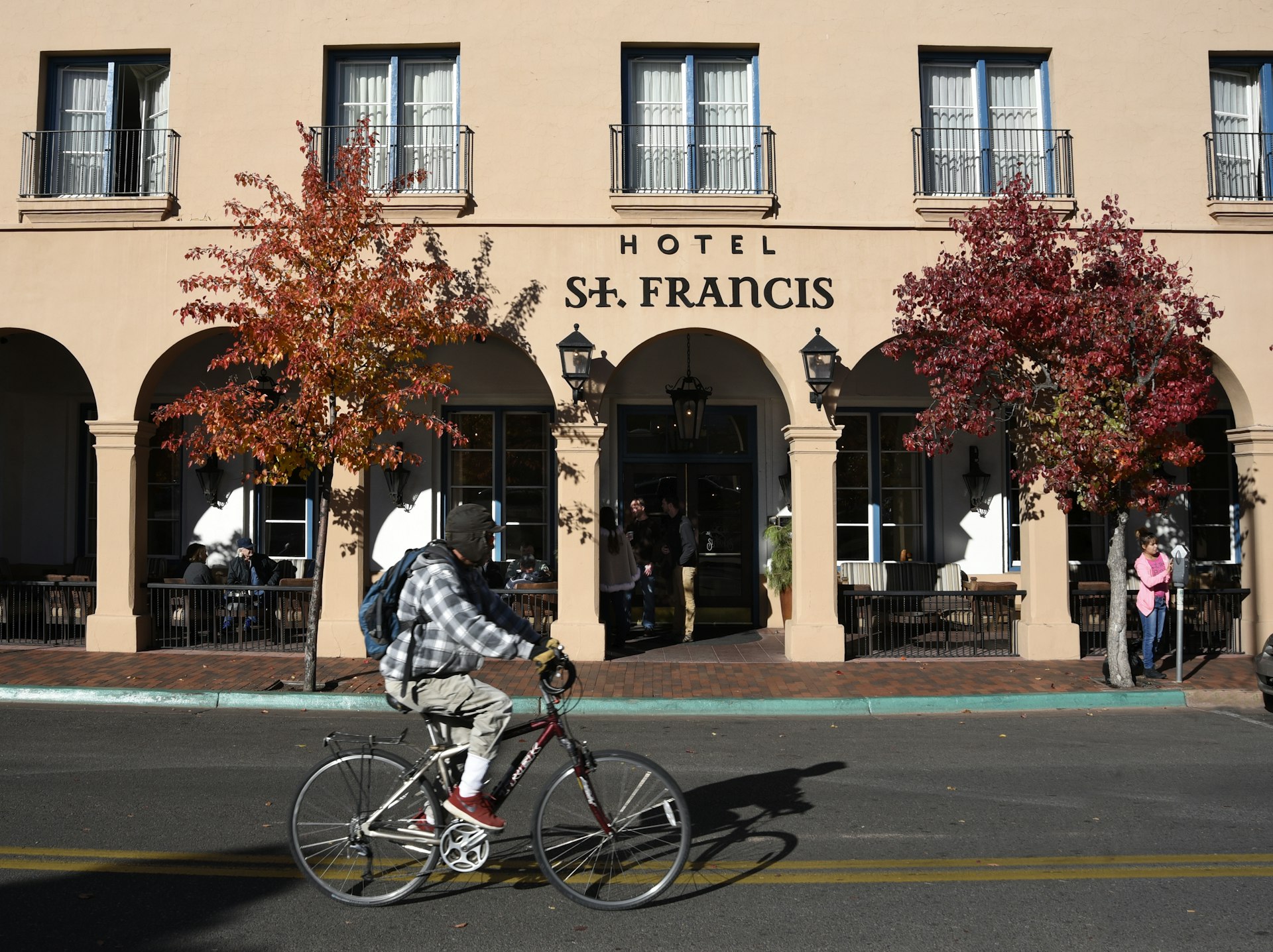 A man rides a bicycle past the entrance to the Hotel St. Francis in Santa Fe, New Mexico.