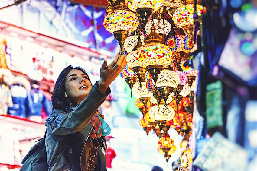 Shopping in Istanbul's Grand Bazaar Young woman with her hand on a strand of lights in Grand Bazaar, Istanbul, Turkey