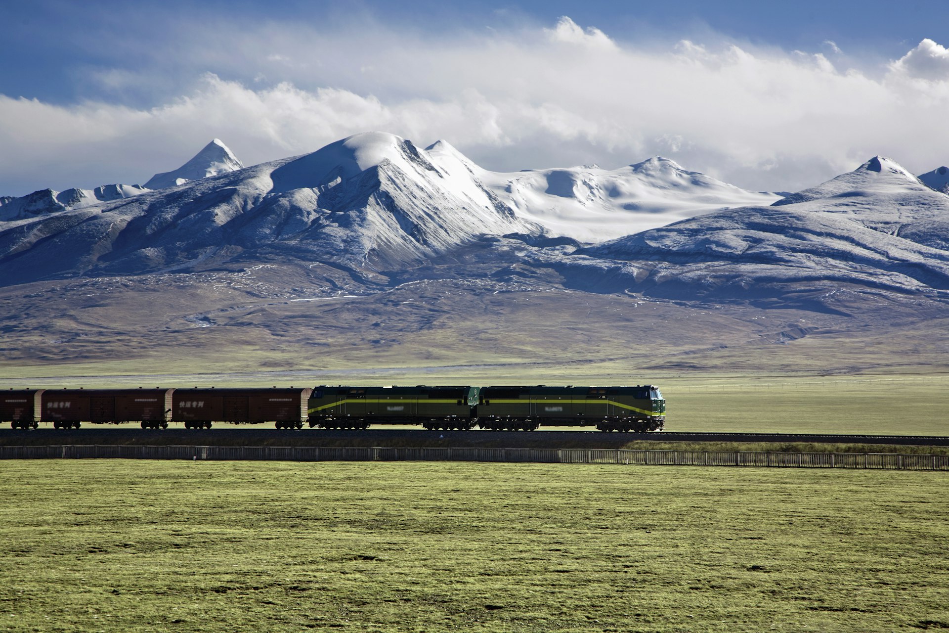 A train on the Qinghai-Tibet Railway, passing in front of snow-capped peaks