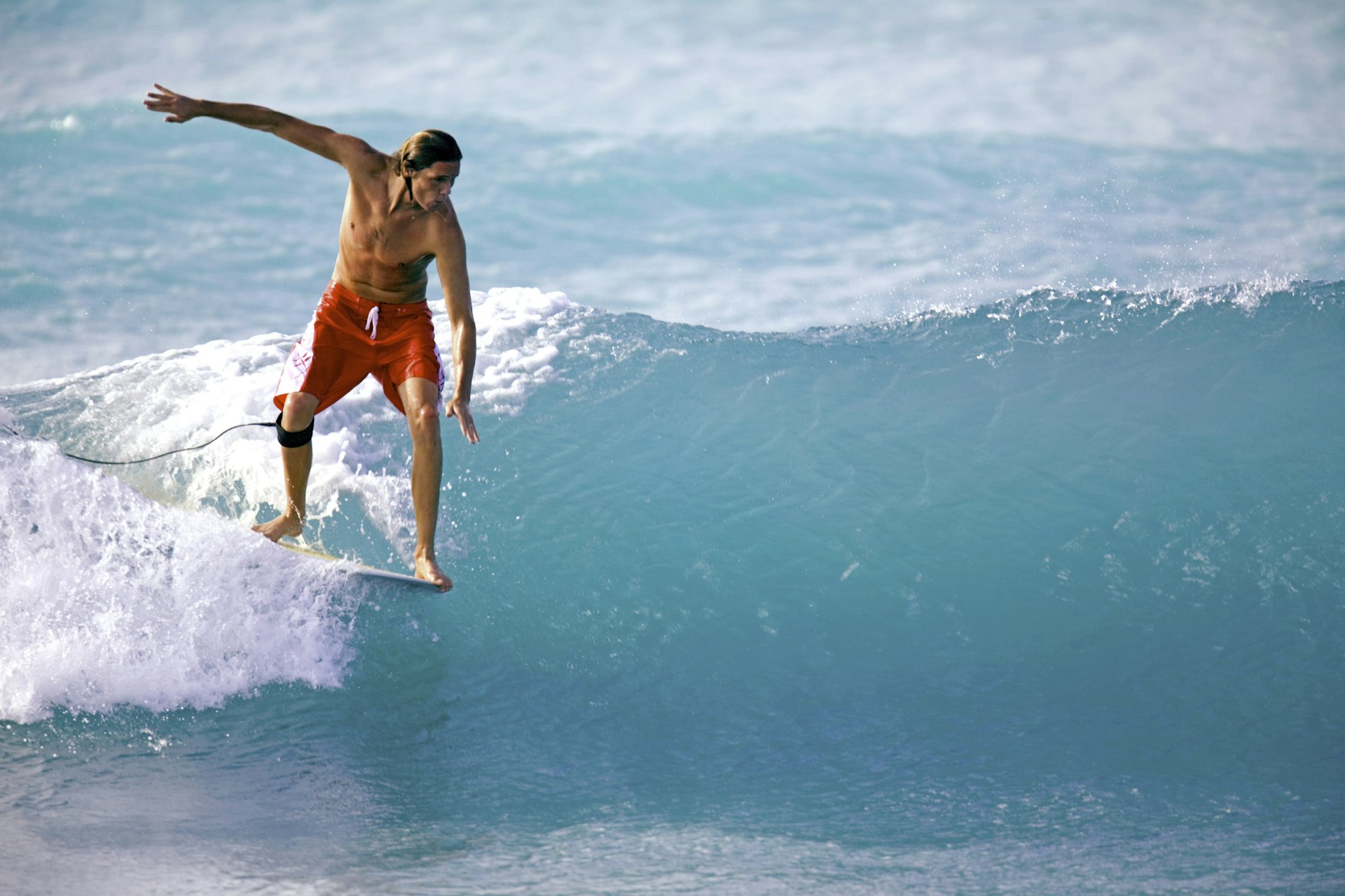 A surfer in red swim trunks at South Point, Barbados