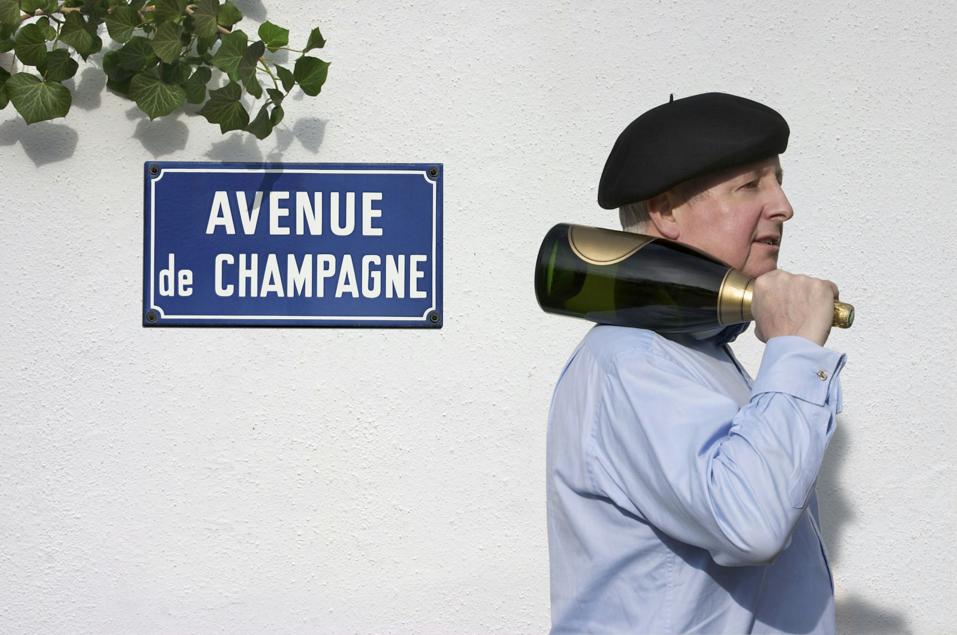 A man holding a bottle of Champagne on the 'Avenue of Champagne' in Epernay
