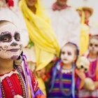 Hispanic children with painted faces celebrate Dia de los Muertos in San Francisco.