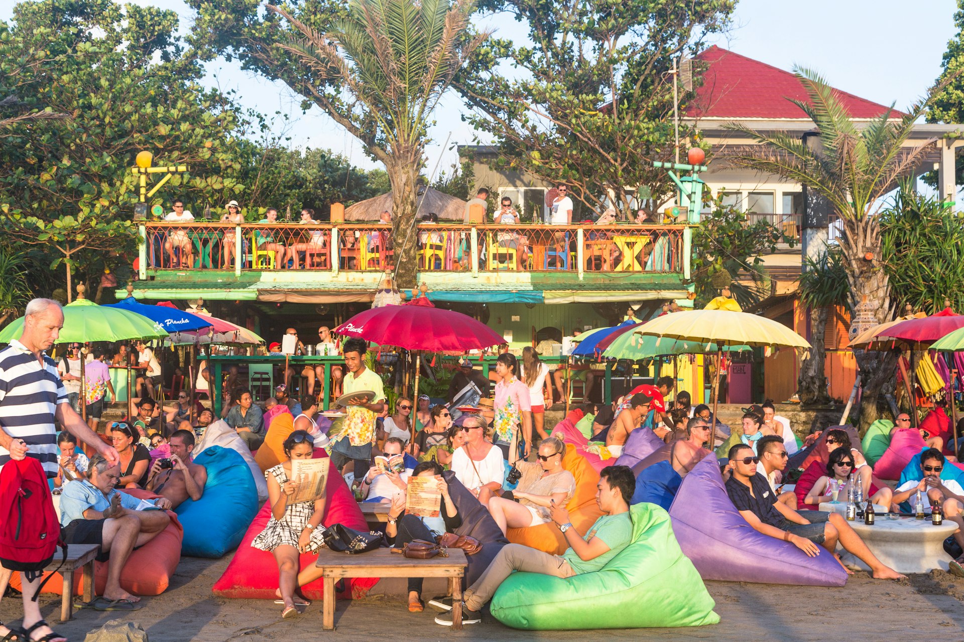 Tourists enjoy a drink in a beach bar along Seminyak beach, in Bali