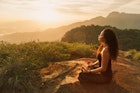 Young woman meditating on a mountain top in Rio de Janeiro.
