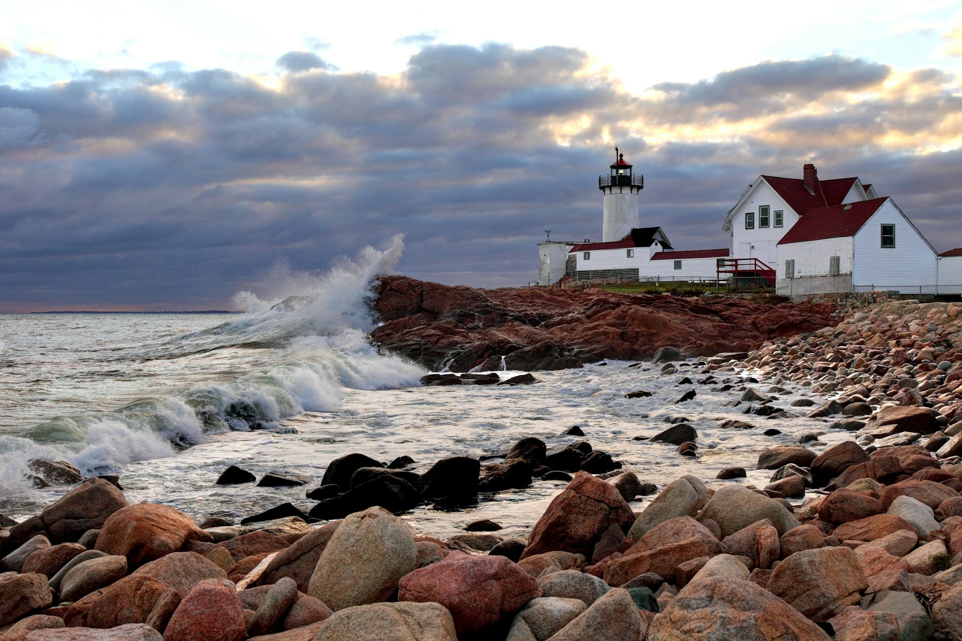 Wave crashing on the rocks near Eastern Point Lighthouse on the eastern tip of Massachusetts Gloucester Harbor. 