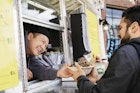 Man buying a bowl of food from a food truck in Richmond.