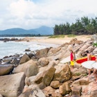 China, Hainan, a group of surfers walking on granite rocks on Hainan Island