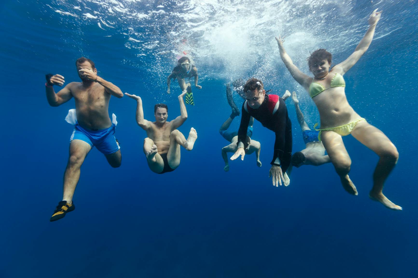 A group of friends enjoying their summer vacation on beautiful island of Hvar in Croatia, having fun together, diving underwater for a photo.