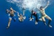 A group of friends enjoying their summer vacation on beautiful island of Hvar in Croatia, having fun together, diving underwater for a photo.