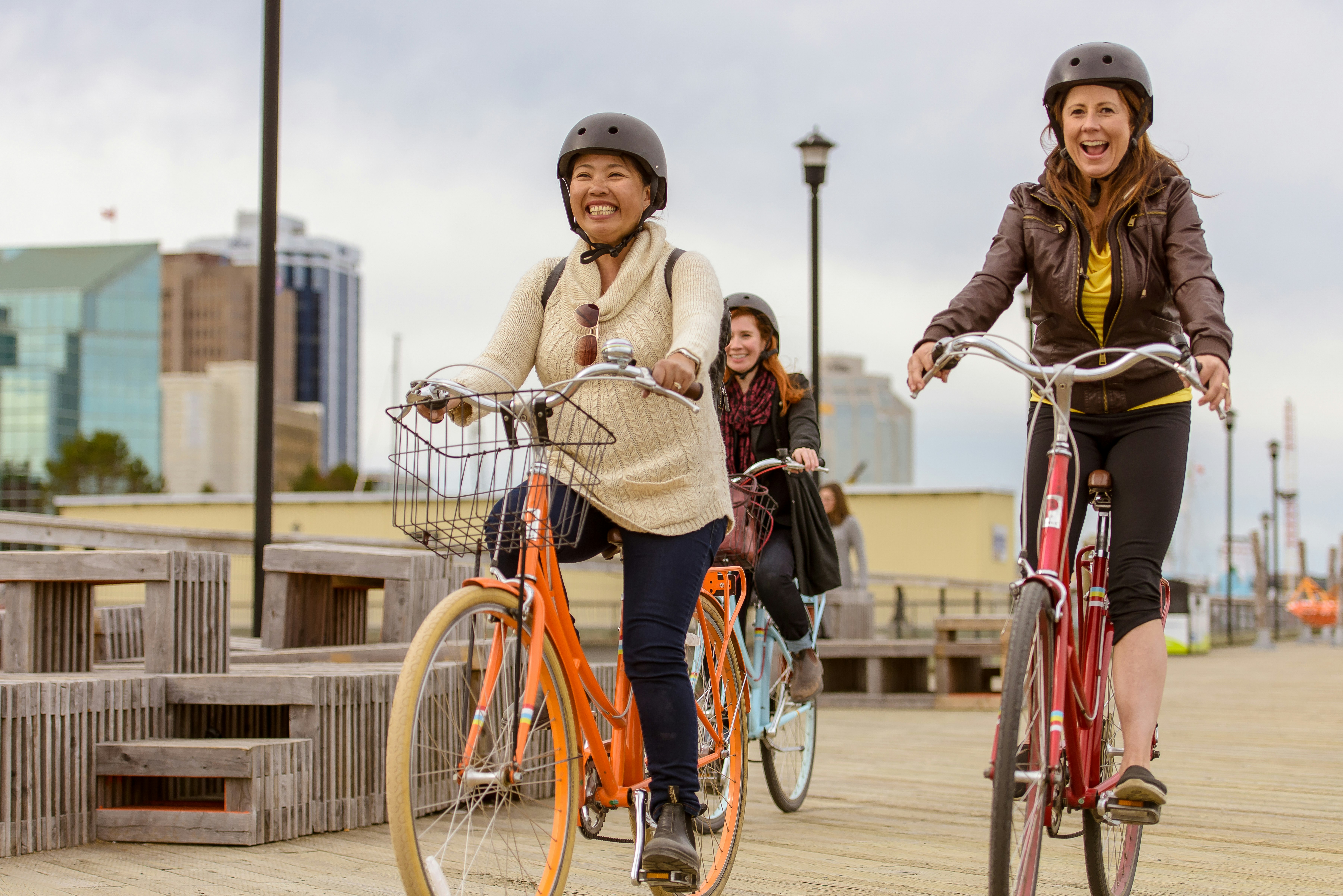 Three people riding bikes across a dock 