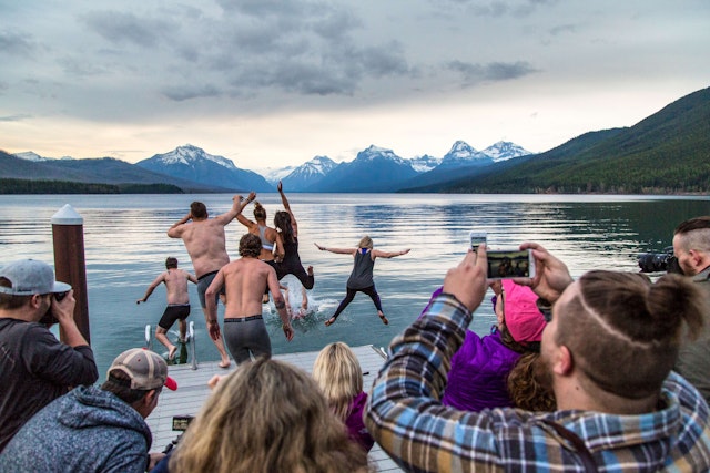 People leaving into water at Glacier National Park Montana NPS