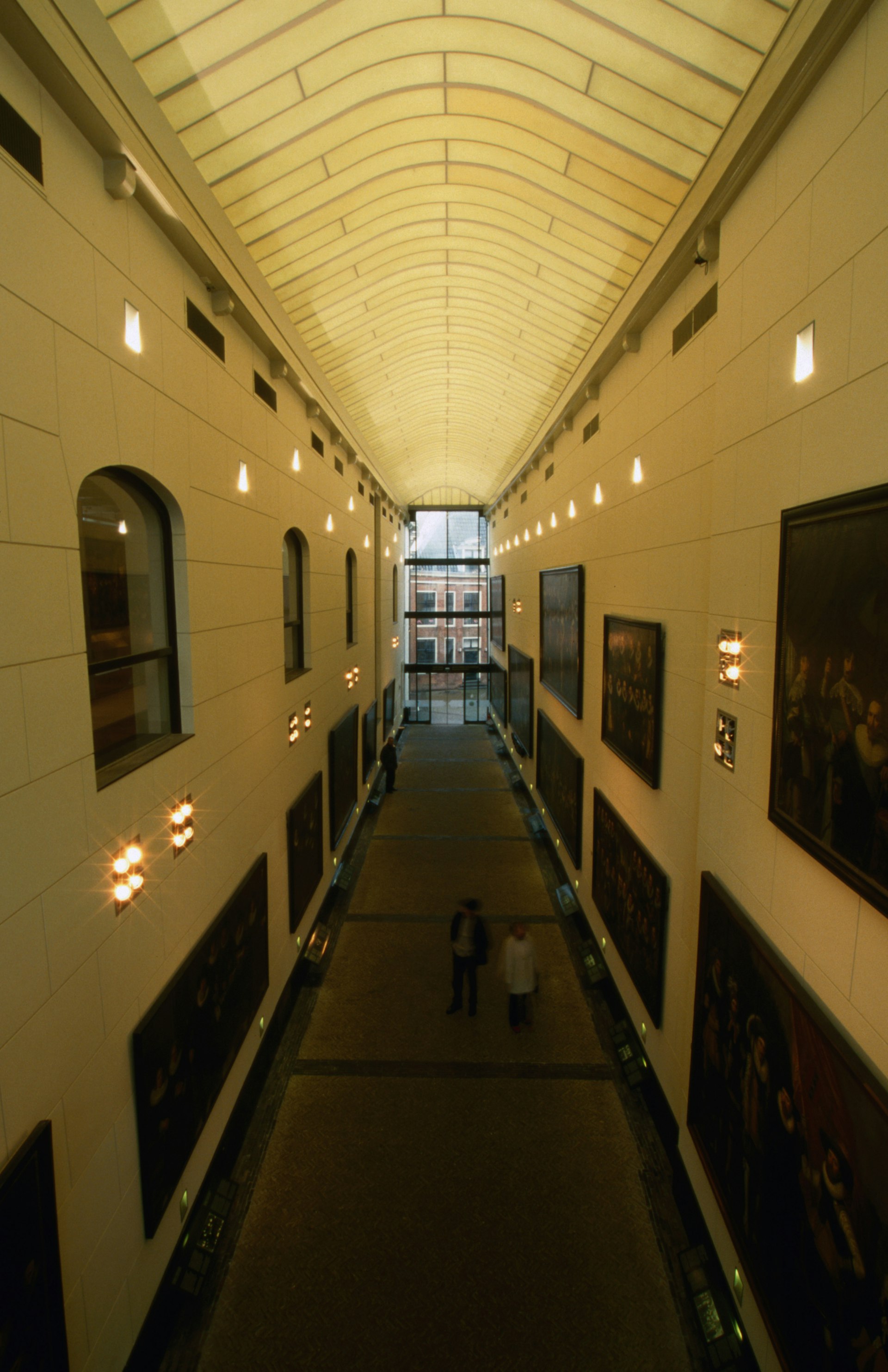 A shot downwards of a long hallway lined with paintings