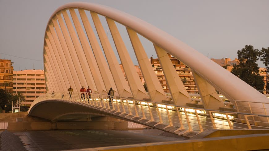 Les gens qui marchent sur le Puente de Calatrava (Pont de Calatrava) à Valence, en Espagne, au coucher du soleil
