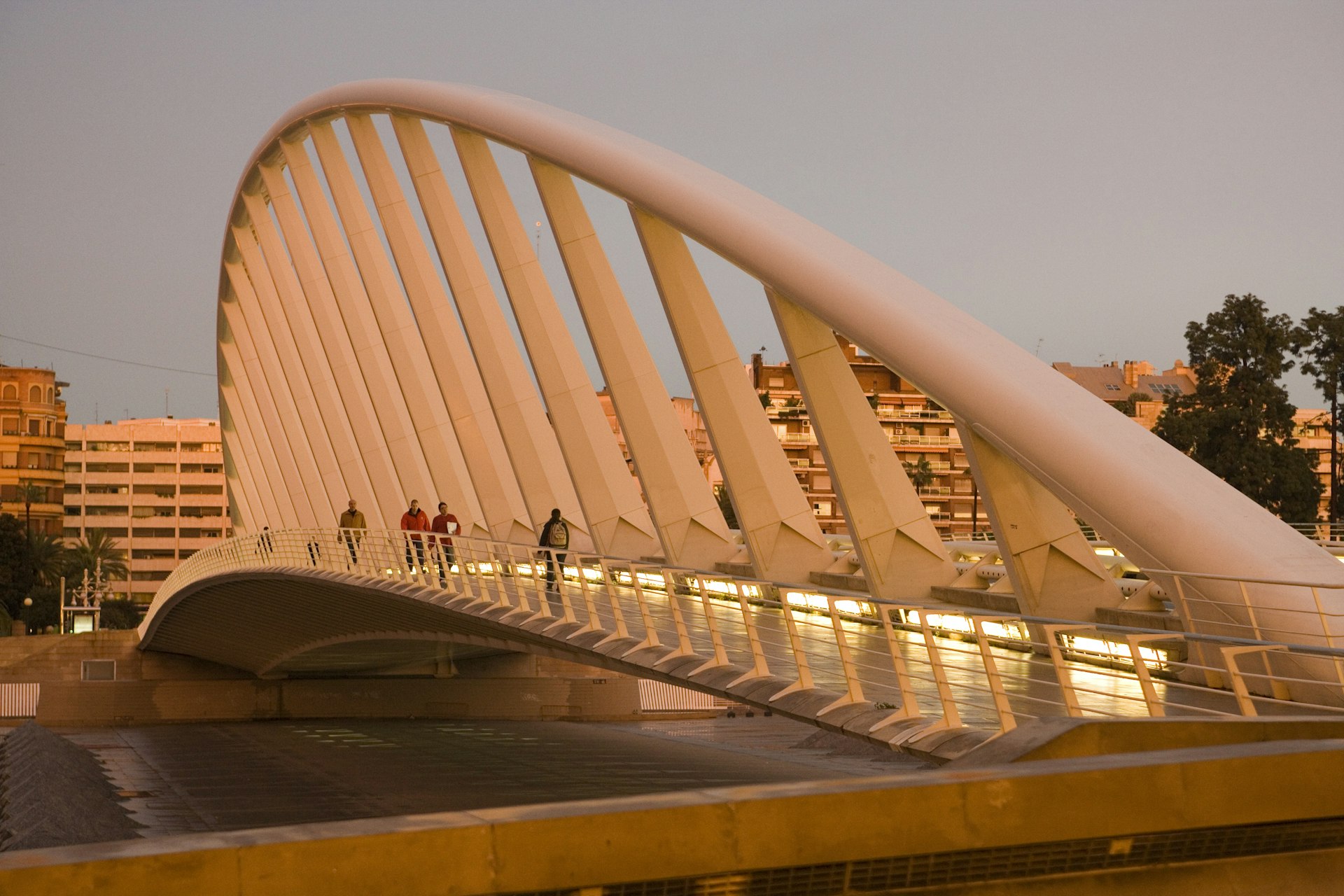 People walking on Puente de Calatrava (Calatrava Bridge) in Valencia, Spain, at sunset
