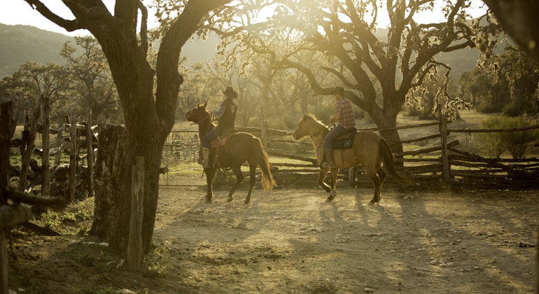 Wranglers on horseback at Dixie Dude Ranch in Bandera, Texas.
