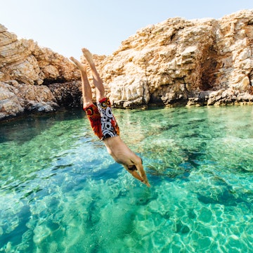 Man diving into clear water at Paros, Greece