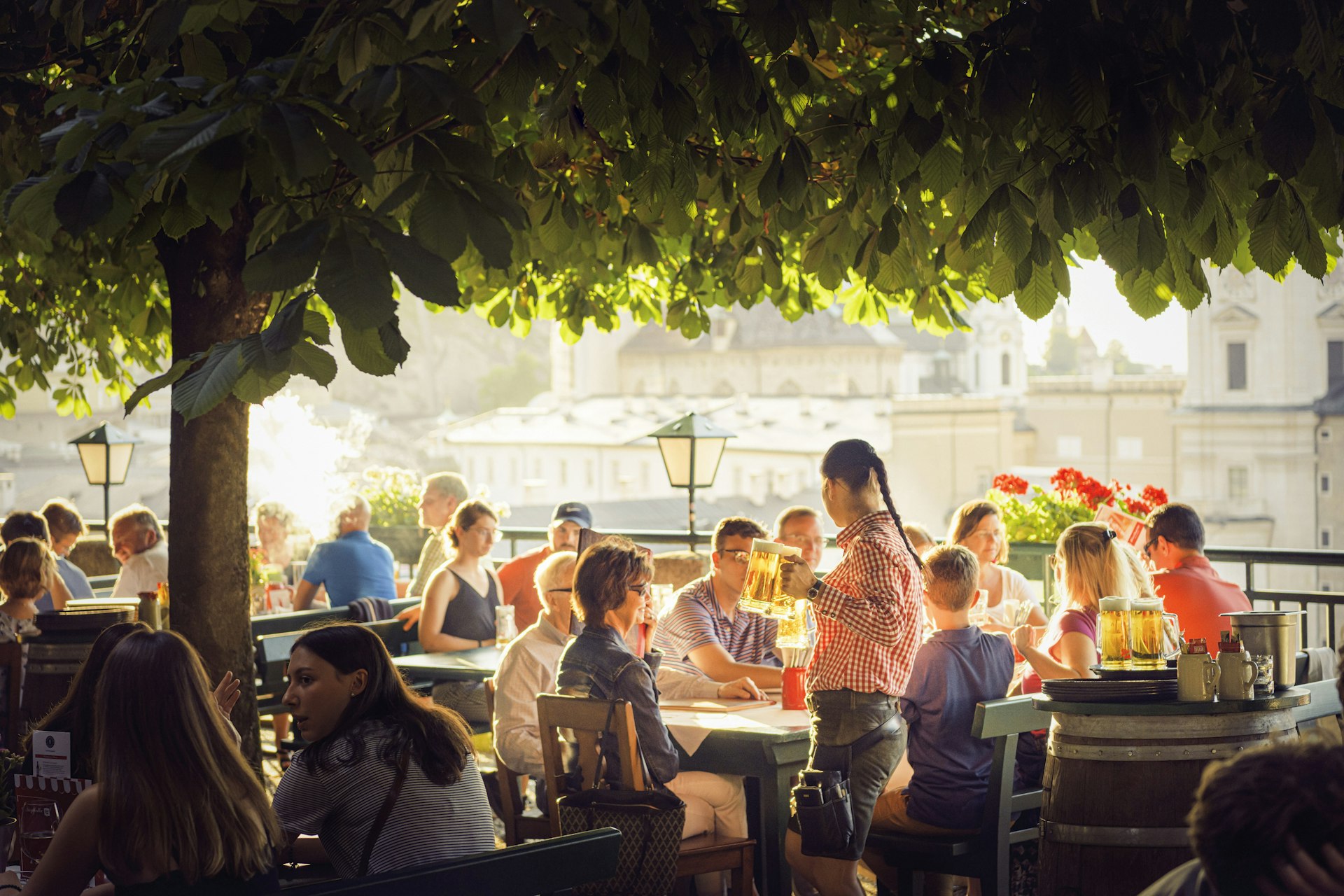 Visitors drinking in the sun at Stieglkeller's beer garden. Salzburg