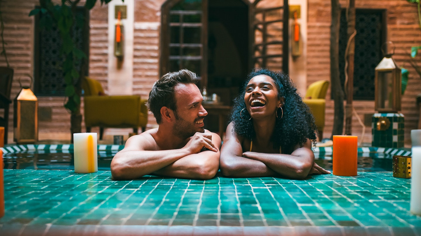 Multiracial couple relaxing in a swimming pool