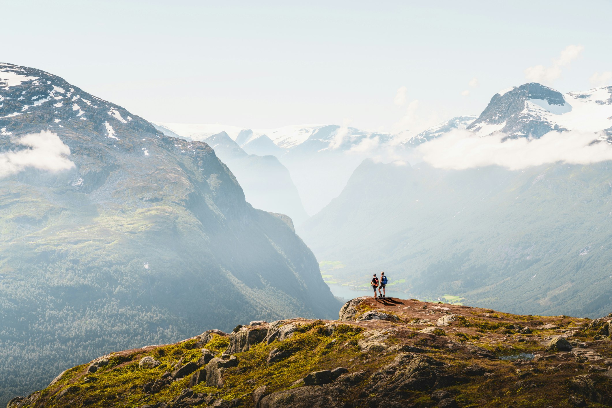 Tourists admiring the view from the top of a mountain in Loen, Norway. The valley stretches on for miles.