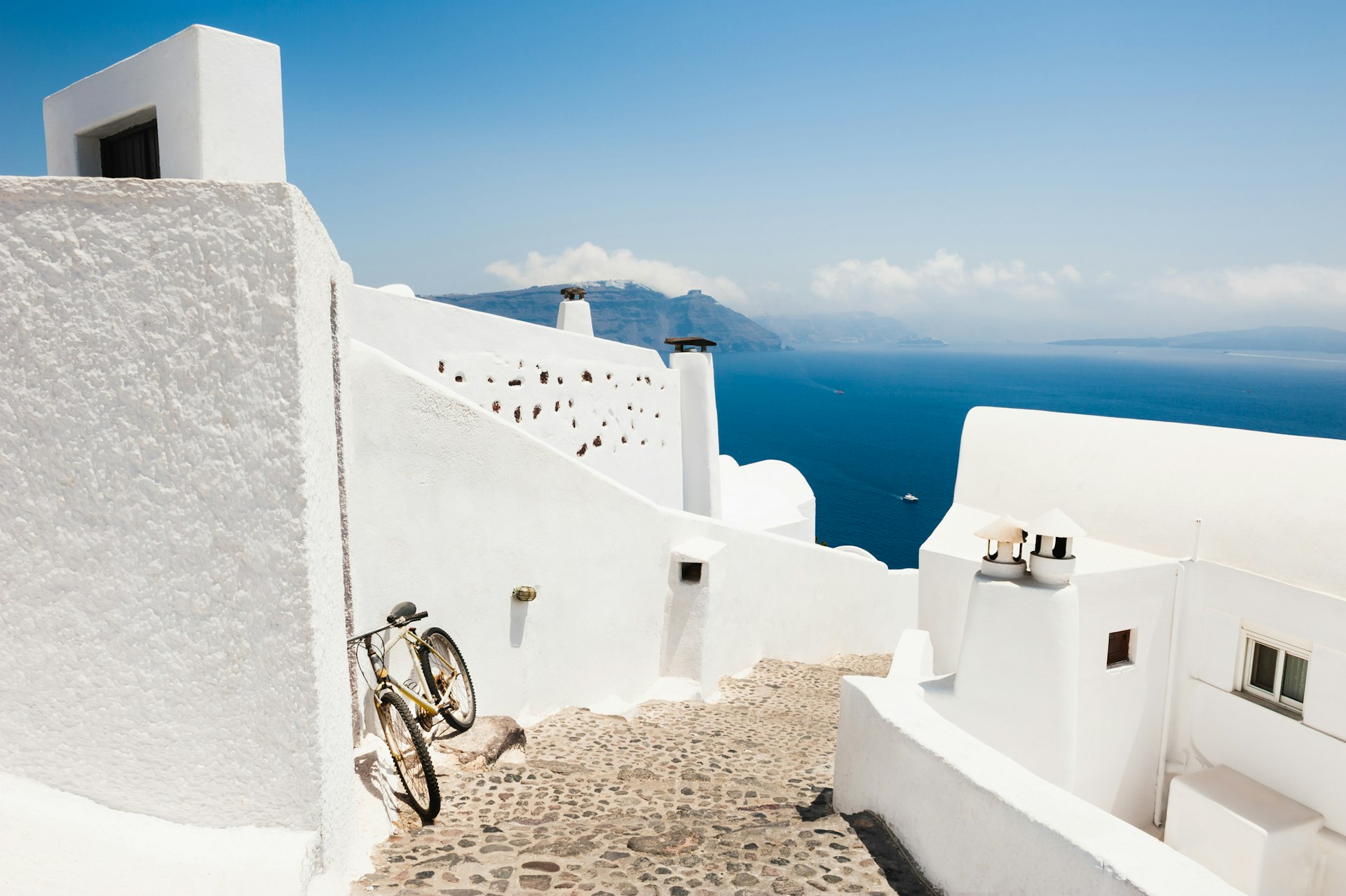 A lone bicycle resting against a whitewashed wall in Santorini, Greece