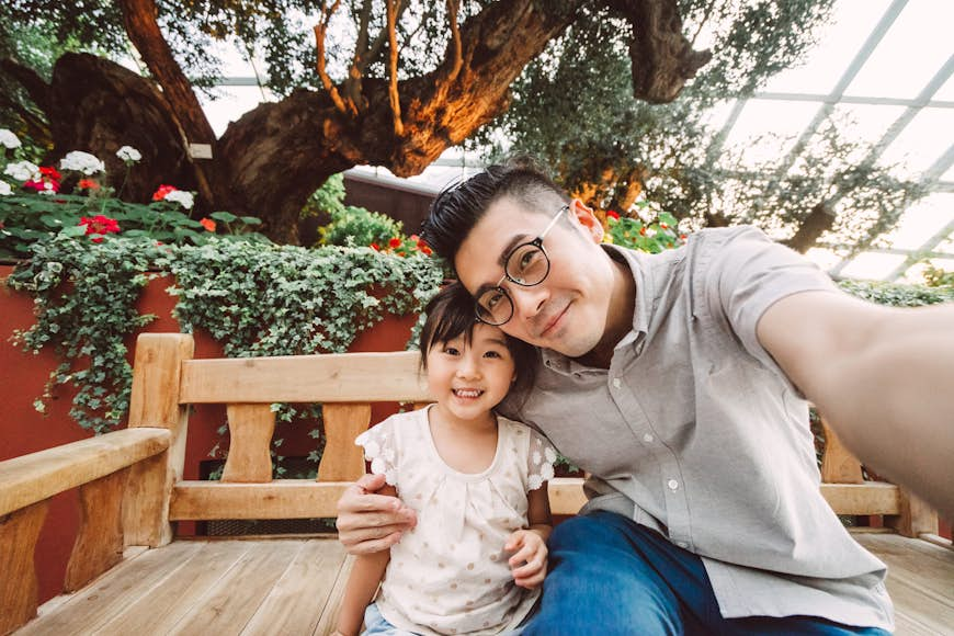 Dad talking selfie with daughter in garden