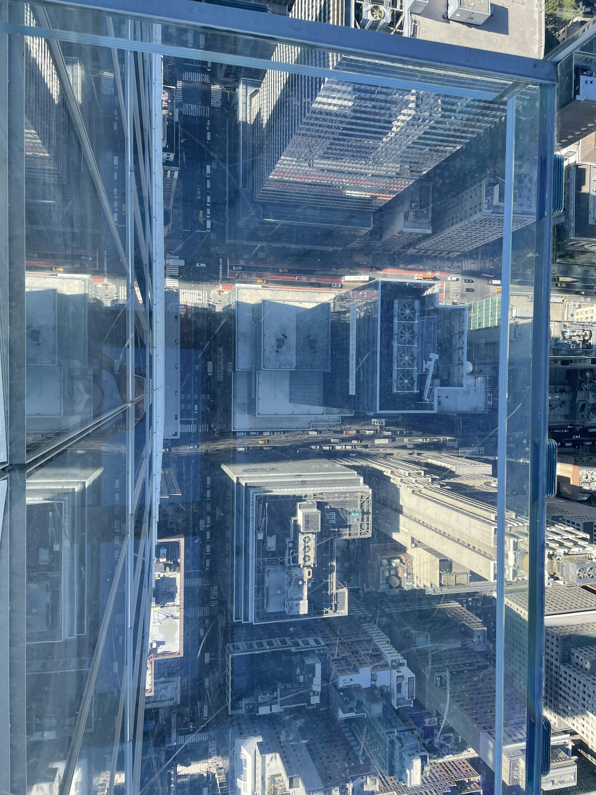 A transparent skyscraper floor overlooking a city below