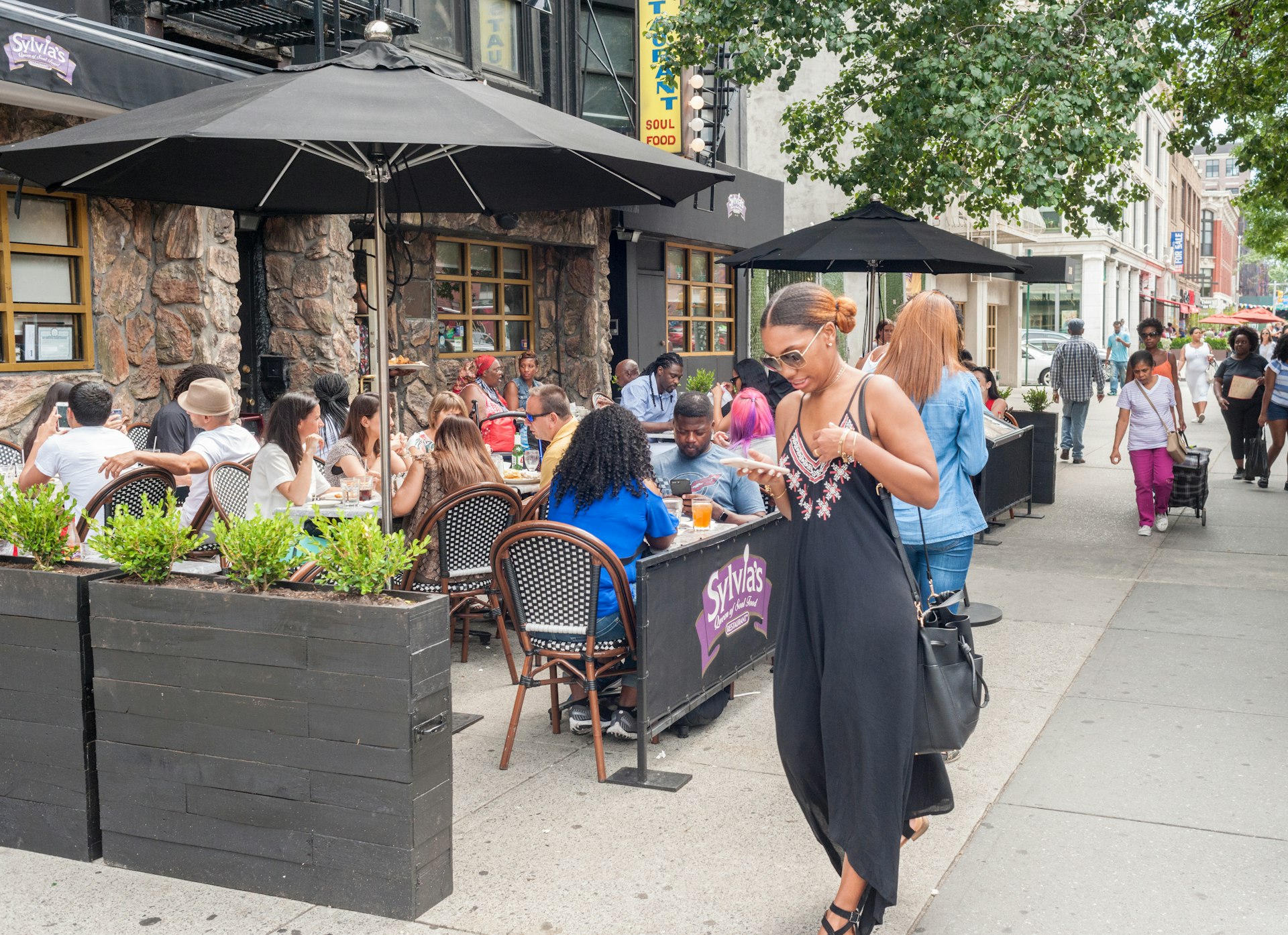 Al fresco dining outside the world-renowned Sylvia's restaurant in Harlem, New York