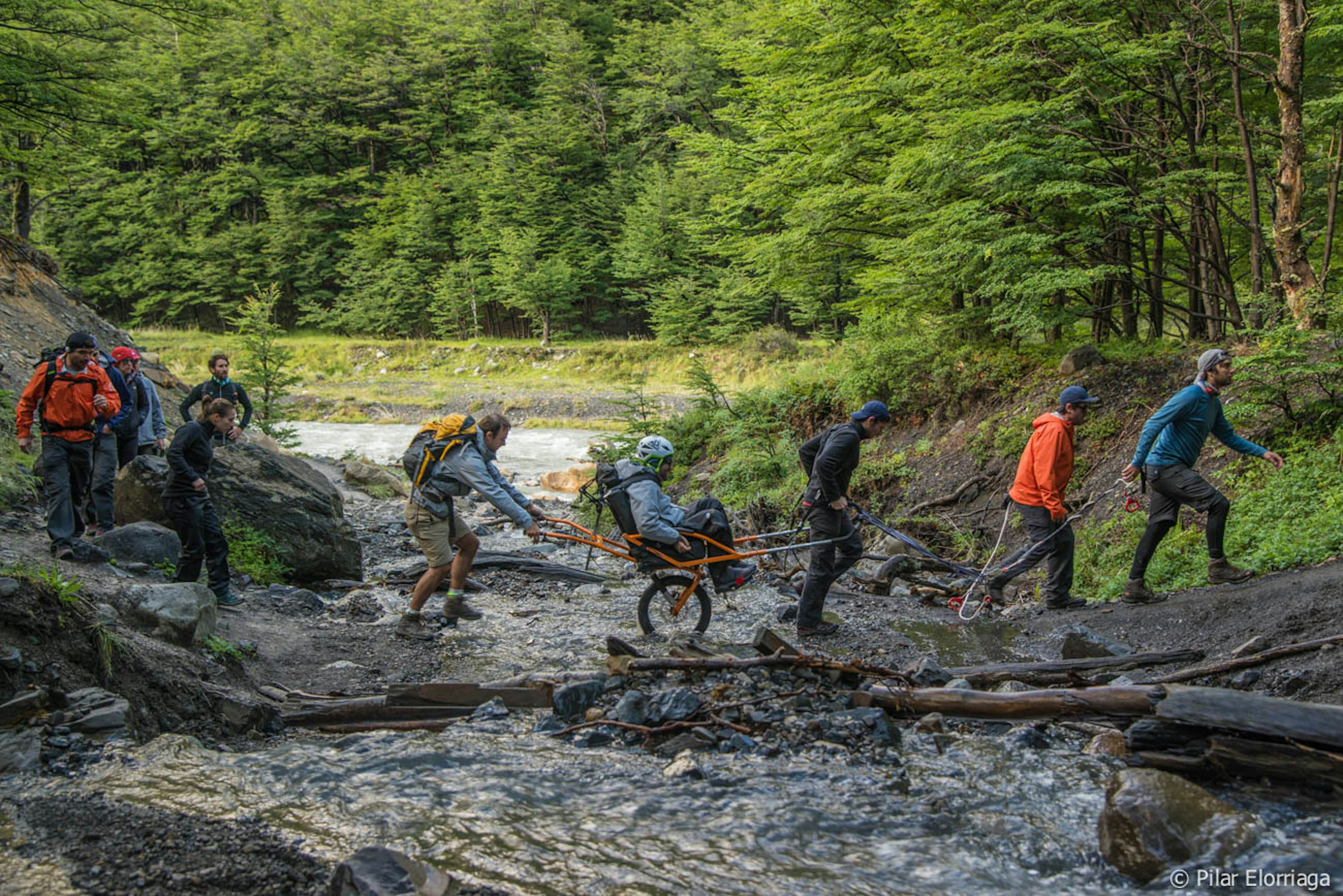 A group of trekkers cross a mountain stream on the W Trek in Torres del Paine, Chile