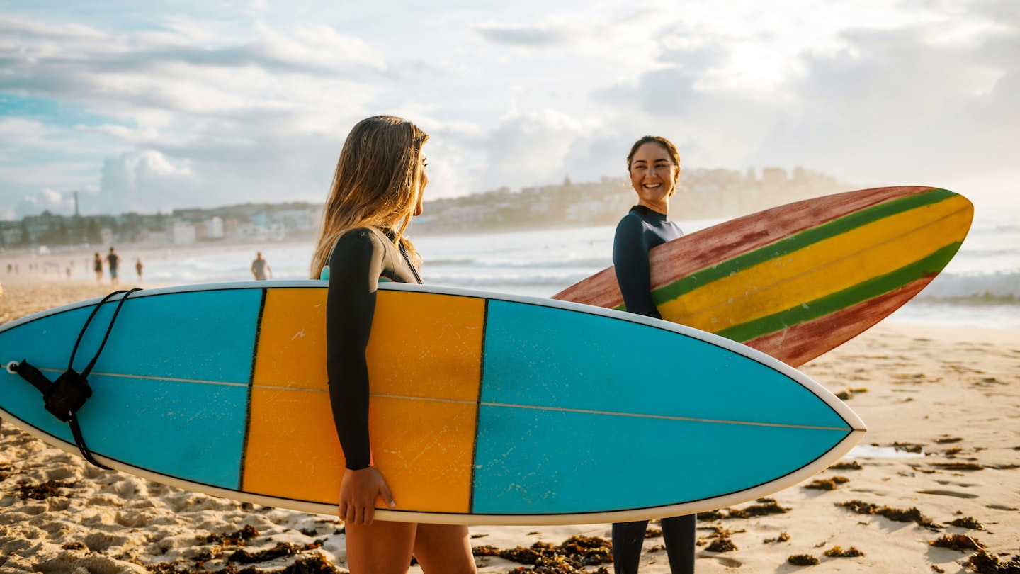 Two female friends with surfboards.