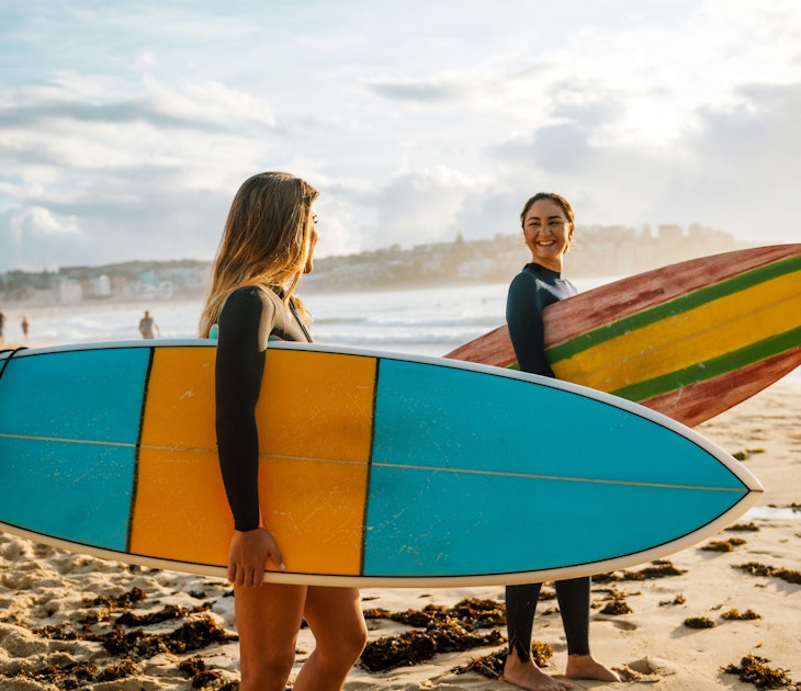 Two female friends with surfboards.
