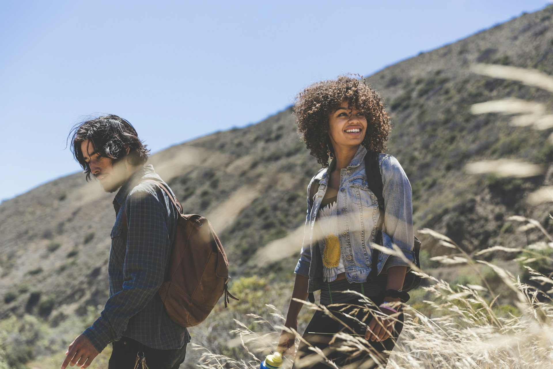 Smiling young woman hiking with boyfriend on sunny day