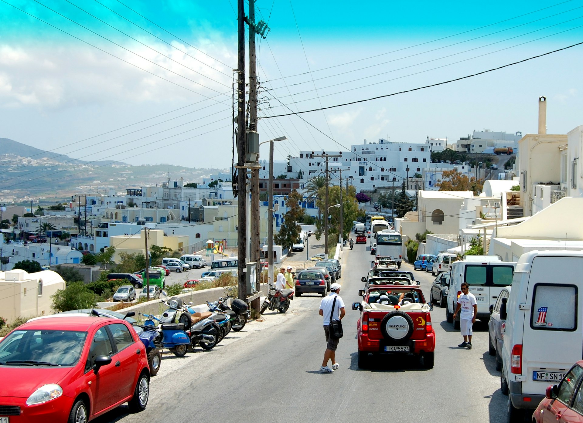 A queue of cars along a narrow street in Santorini