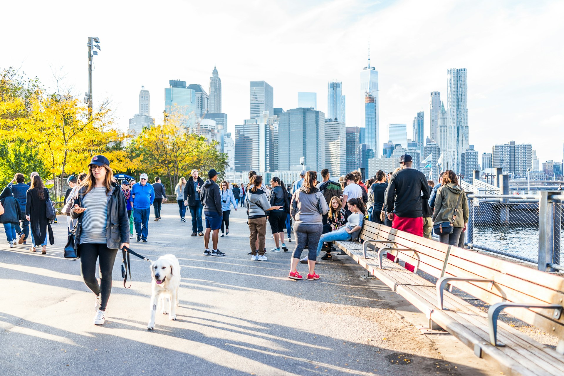 People walking in Brooklyn Bridge Park on the East River on a sunny day