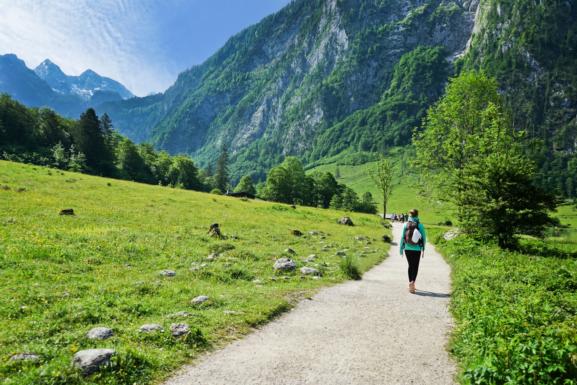Hikers walking on a trail through a mountainous region of the National park Berchtesgaden, Austria