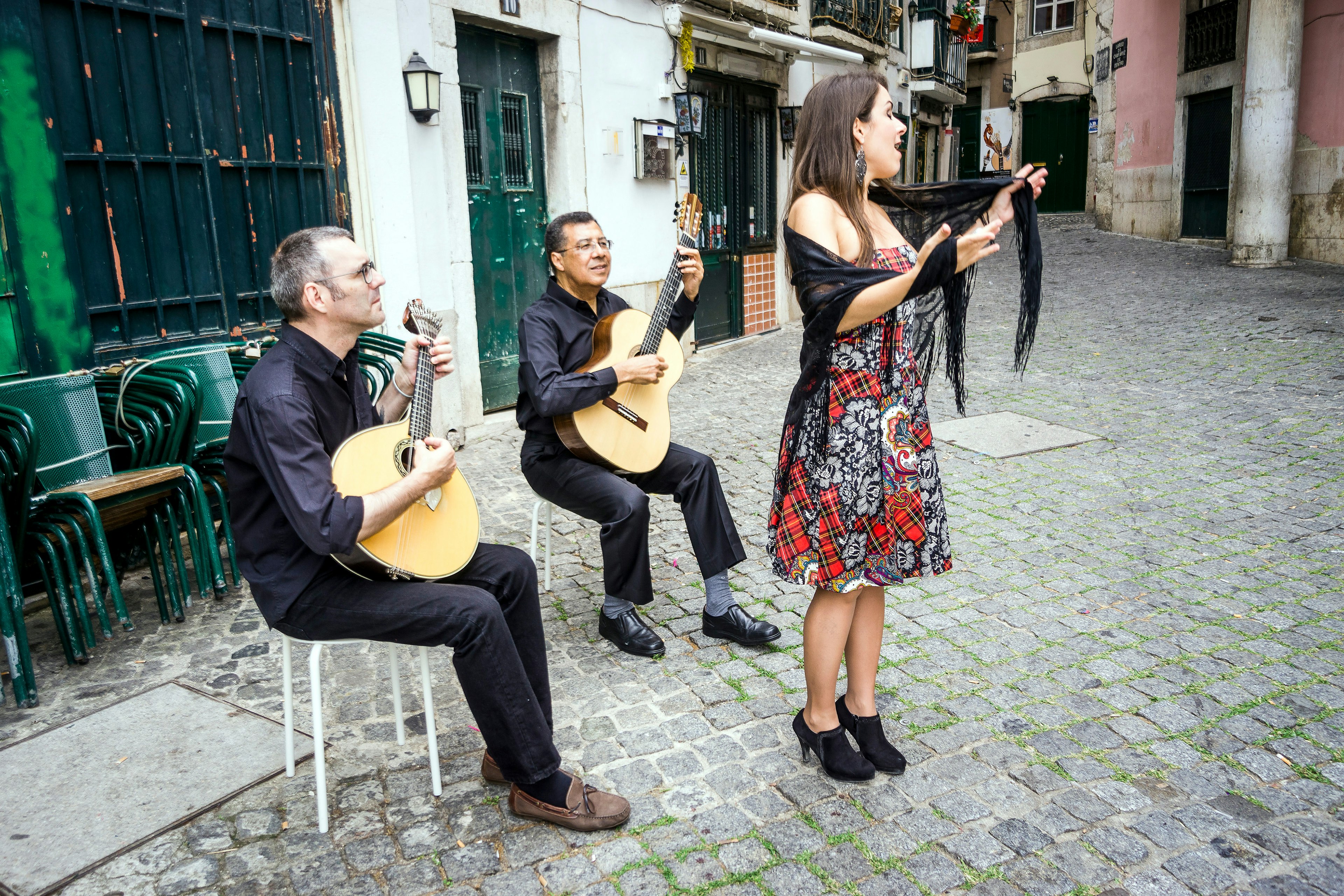 Two guitarists and a singer performing in the street in Alfama