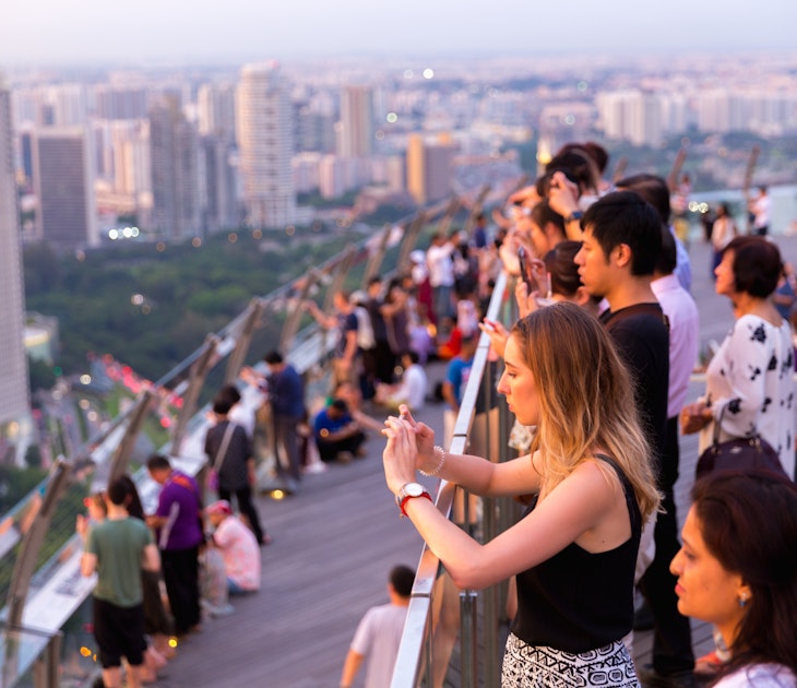 MAY 12, 2017: Visitors watching the sunset from the Observation Deck Skypark of Marina Bay Sands hotel.