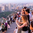 MAY 12, 2017: Visitors watching the sunset from the Observation Deck Skypark of Marina Bay Sands hotel.