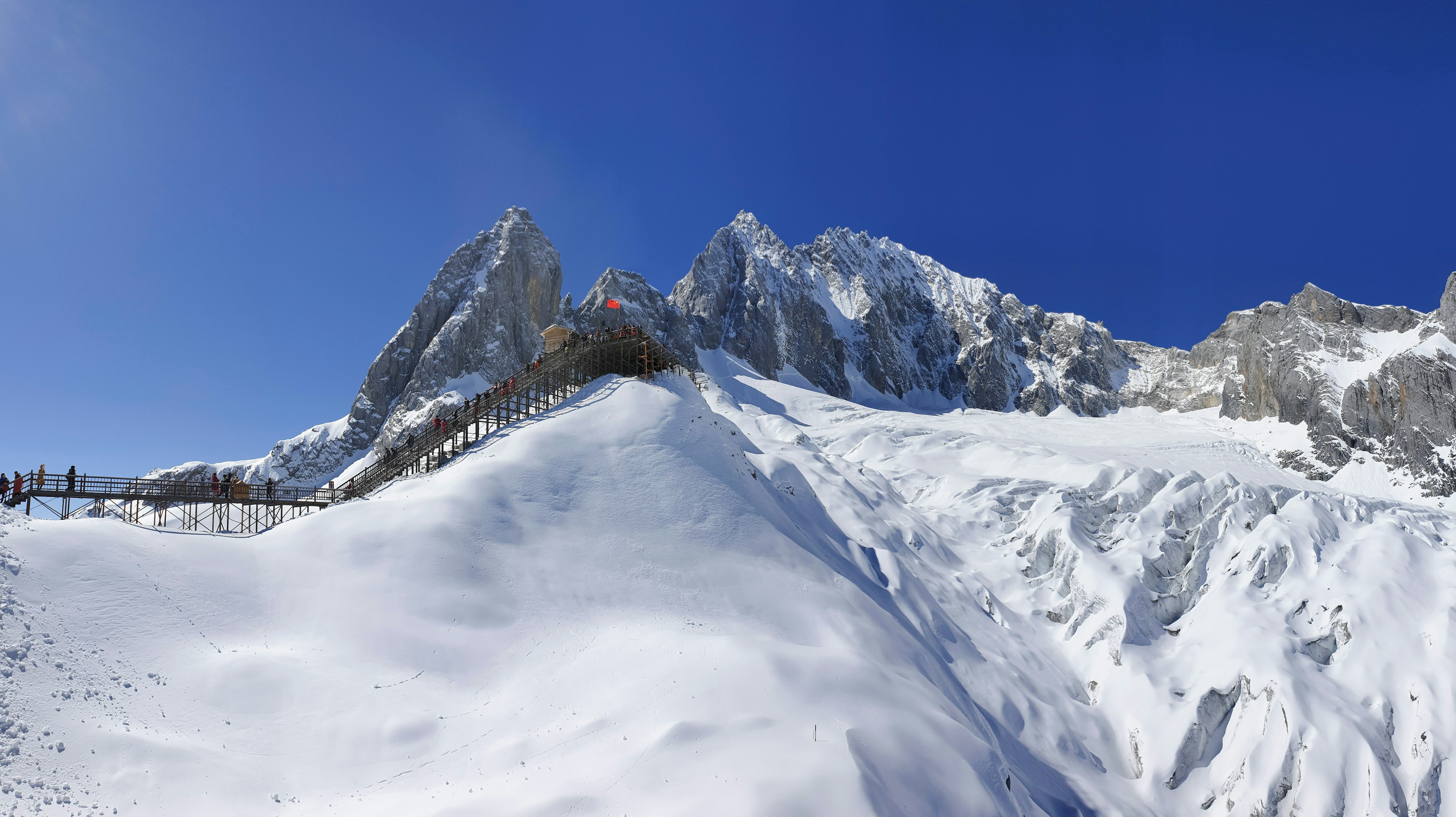 People climbing a high altitude glacier at Jade Dragon Snow Mountain