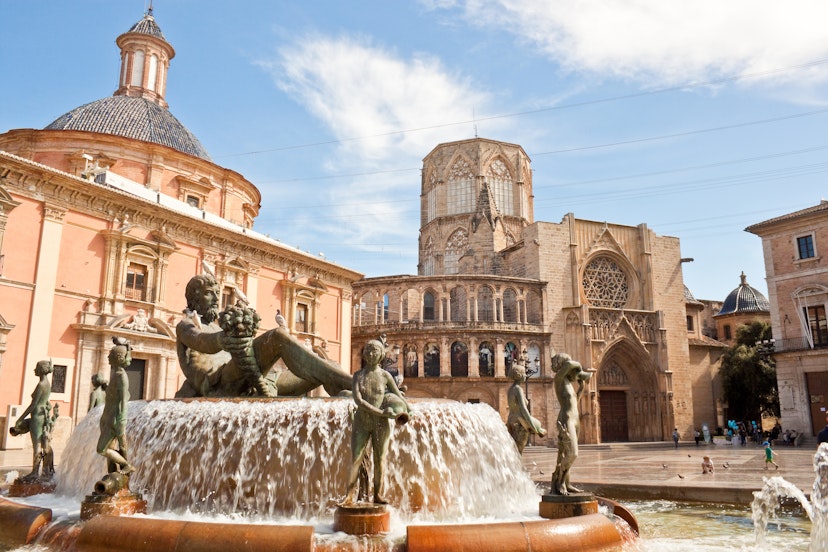 Valencia, Spain - April 10, 2013: Virgin square with Turia fountain, Basilica of Our Lady of the Forsaken and  Apostles Gate of the Valencia cathedral.