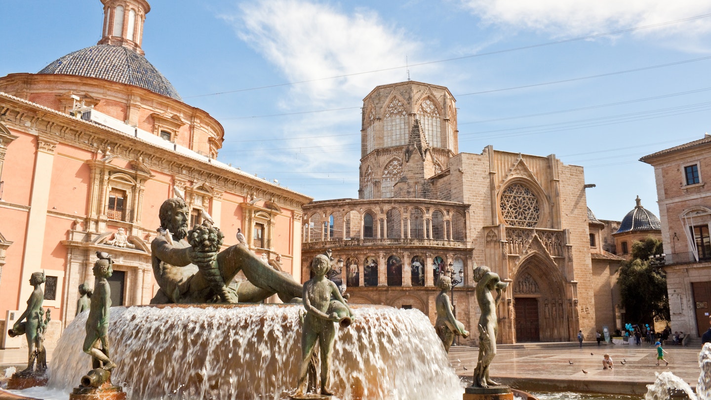 Valencia, Spain - April 10, 2013: Virgin square with Turia fountain, Basilica of Our Lady of the Forsaken and  Apostles Gate of the Valencia cathedral.