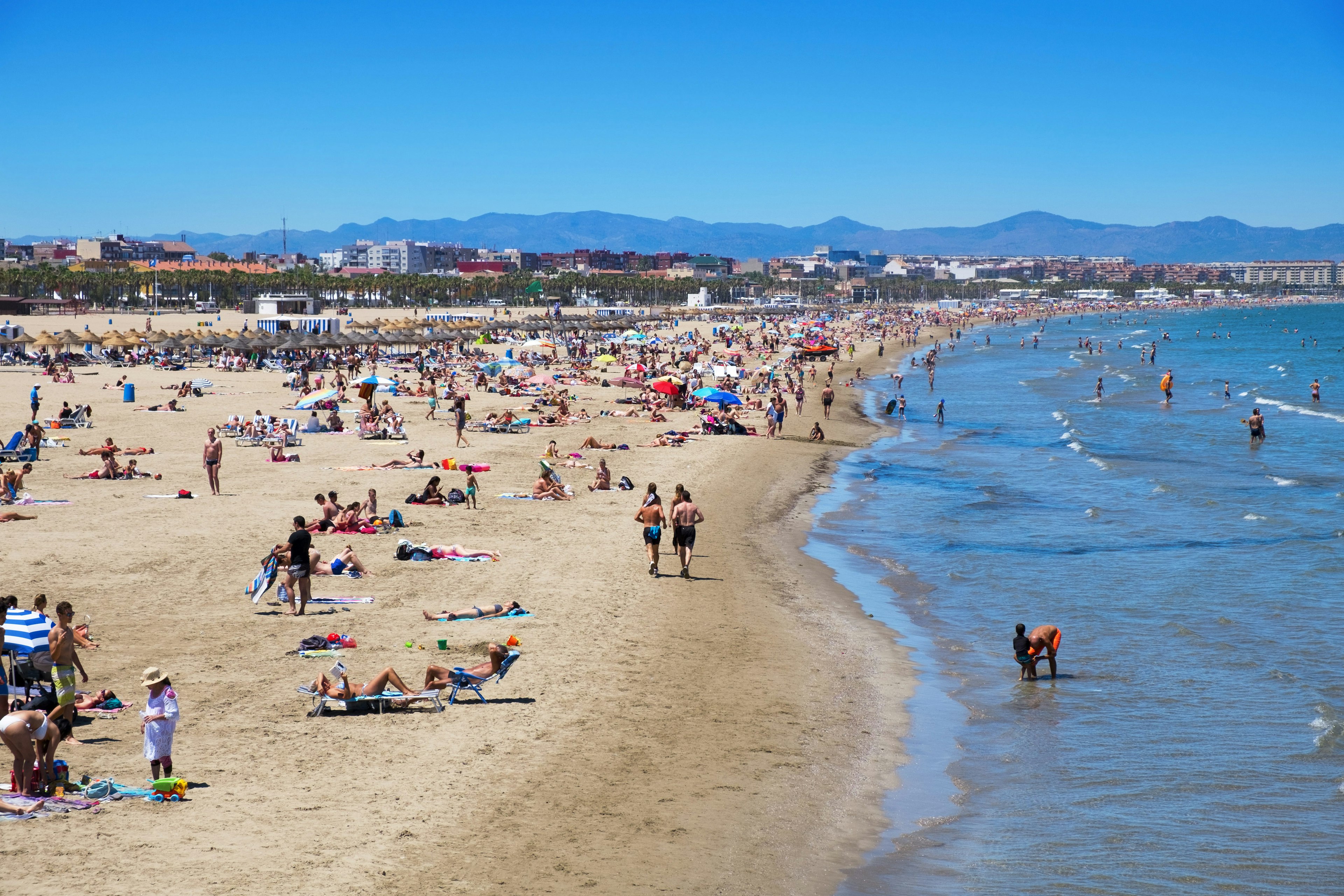 Sunbathers at El Cabanyal and La Malvarrosa beaches on a clear sunny day